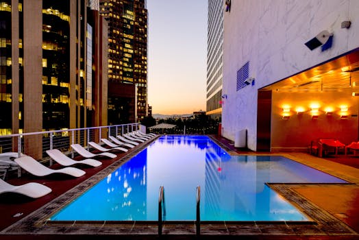 pexels-photo-261102-261102 Elegant rooftop pool with cityscape backdrop at sunset, reflecting urban luxury.